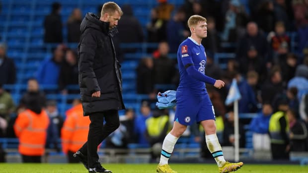 Graham Potter walking off the field after a Chelsea loss.